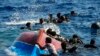 Migránsok úsznak felborult facsónakjuk mellett az olaszországi Lampedusa sziget közelében 2022. augusztus 11-én