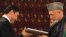 Afghan President Hamid Karzai (right) and his Turkmen counterpart, Gurbanguly Berdymukhammedov, exchange one of their agreements in Kabul