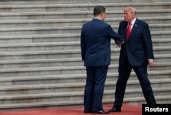 Donald Tramp Pekindəki Xalq Yığıncaqları Sarayına gəlişi zamanı Si Cinpin ilə əl sıxışır.