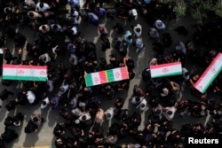 People carry coffins as they attend the funeral of the victims following an air strike on a school in Minab, Iran, on March 3.