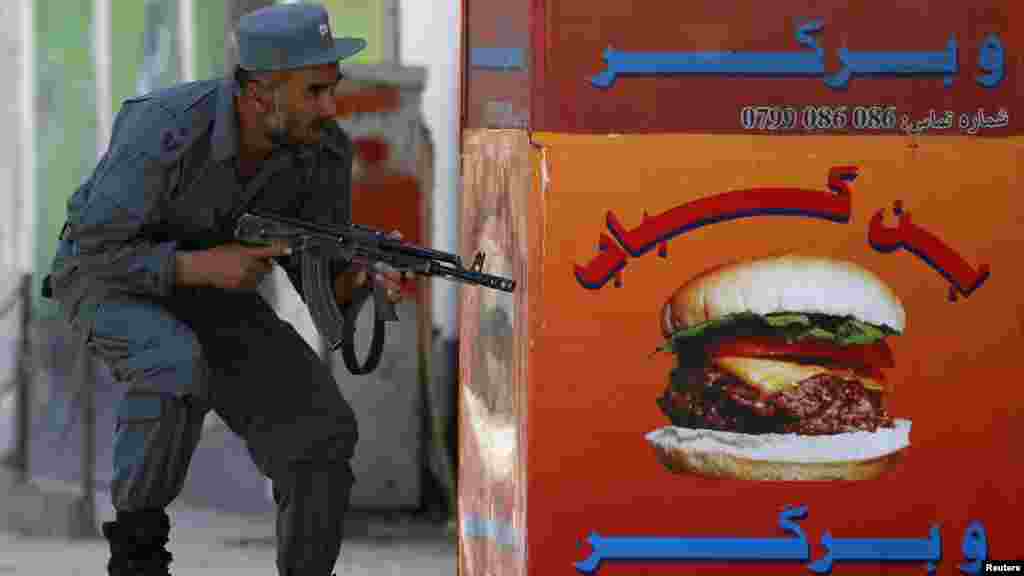 An Afghan policeman takes up a position at the site of an attack in Kabul on April 15. (REUTERS/Omar Sobhani)