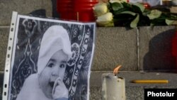 Armenia - A photographs of 6-month-old Seryozha Avetisian (L) is displayed during a candlelight vigil in Yerevan, 20Jan2015.