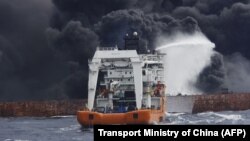 The Chinese offshore supply ship Shen Qian Hao sprays foam on the burning oil tanker Shanchi at sea off the coast of eastern China on January 12.