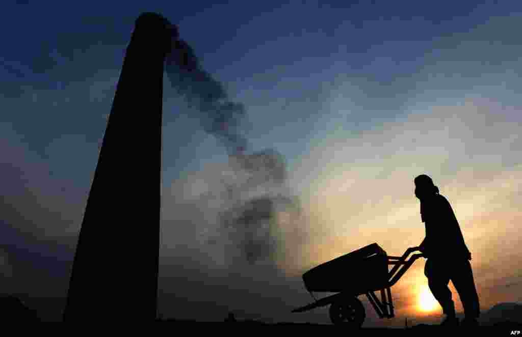 An Afghan day labourer pushes his wheelbarrow at a factory on the outskirts of Jalalabad in Nangarhar province. (AFP/Noorullah Shirzada)