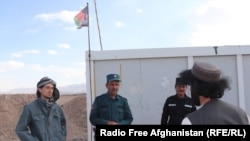 Naqibullah (right) explains demining techniques to three Afghan police officers at a checkpoint outside Tarin Kowt.