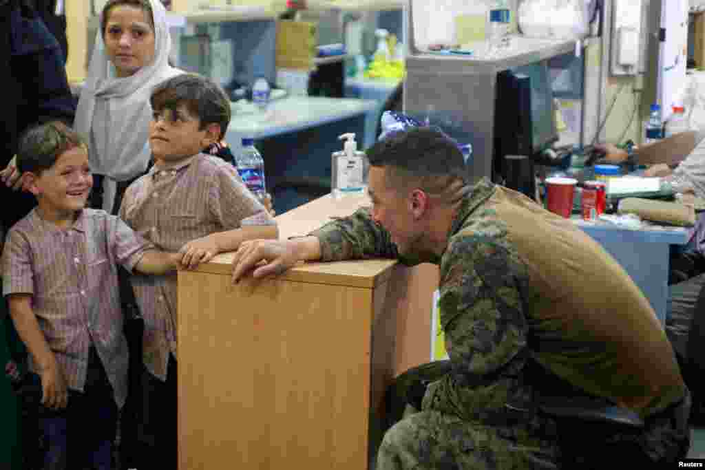 Një ushtar amerikan duke biseduar me disa fëmijë në Aeroportin Hamid Karzai në Kabul
