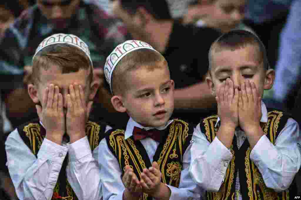 Young Kosovar Muslims take part in a prayer during a celebration of Eid al-Fitr, which marks the end of the fasting month of Ramadan, at the Sulltan Mehmet Fatih mosque in Pristina. (AFP/Armend Nimani)