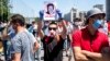 A man holds up a sign showing Gulshat Asylbaeva, a member of parliament, during a protest in June against the "false information" bill they say will imperil press and Internet freedoms in the country. Asylbaeva authored the bill.