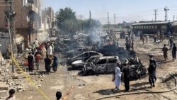 People and police officers gather after a blast near a railway track in Quetta, the regional capital of Baluchistan in Pakistan, on May 24.