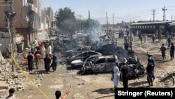 People and police officers gather after a blast near a railway track in Quetta, the regional capital of Baluchistan in Pakistan, on May 24.
