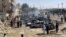 People and police officers gather after a blast near a railway track in Quetta, the regional capital of Baluchistan in Pakistan, on May 24.
