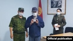 Абакта отургандардын бирине паспорт тапшырылып жатат.