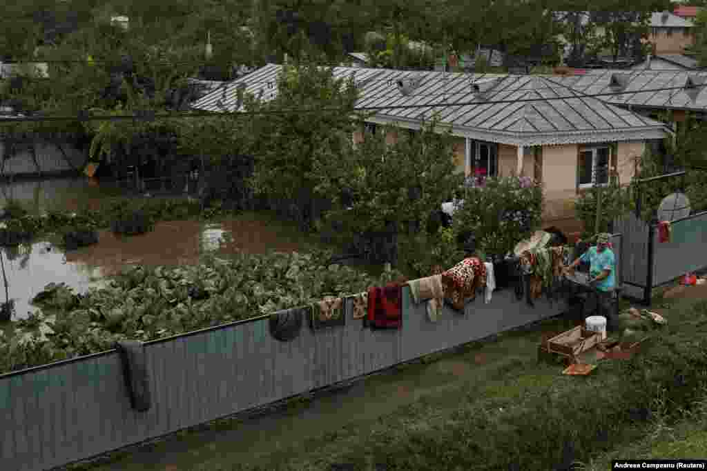 A man salvages personal belongings from his home as floodwaters began to recede in Slobozia Conachi.