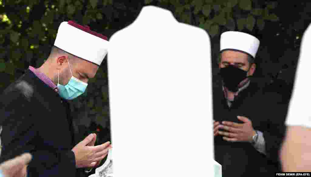 Bosnian muftis wearing protective face masks pray during a funeral ceremony amid the ongoing coronavirus pandemic at a cemetery in Sarajevo, Bosnia and Herzegovina. (epa-EFE/Fehim Demir)&nbsp;