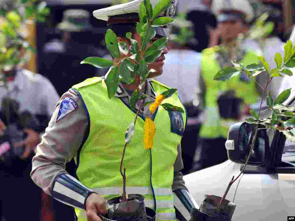 Інданэзія: паліцэйскія раздаюць аўтамабілістам кветкі ў рамках экалягічнай кампаніі ў Джакарце.