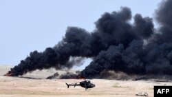 Smoke billows as a helicopter manoeuvres during the Northern Thunder military exercises in Hafr al-Batin, 500 kilometers north-east of the Saudi Capital Riyadh on March 10.