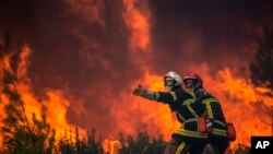 Zjarrfikësit luftojnë një zjarr në një pyll në La Test-de-Buch të Francës, 18 korrik 2022.