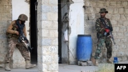 Pakistani soldiers take position as they search a house during a military operation against Taliban militants in the main town of Miran Shah in North Waziristan in July 2014.