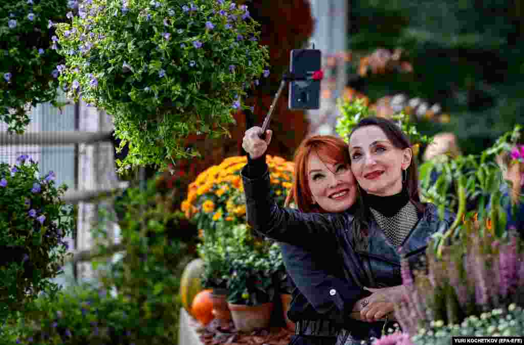 Women take a selfie during the annual Colors of Autumn festival in the botanical garden of Moscow State University. More than 50 new and rare varieties of chrysanthemums and the largest pumpkins in Russia are being presented at the festival. (epa-EFE/Yuri Kochetkov)