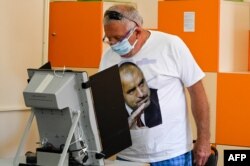 A voter wears a T-shirt featuring Borisov's image at a polling station in Sofia on July 11.