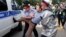 Kazakh police detain a demonstrator in Almaty on June 12.