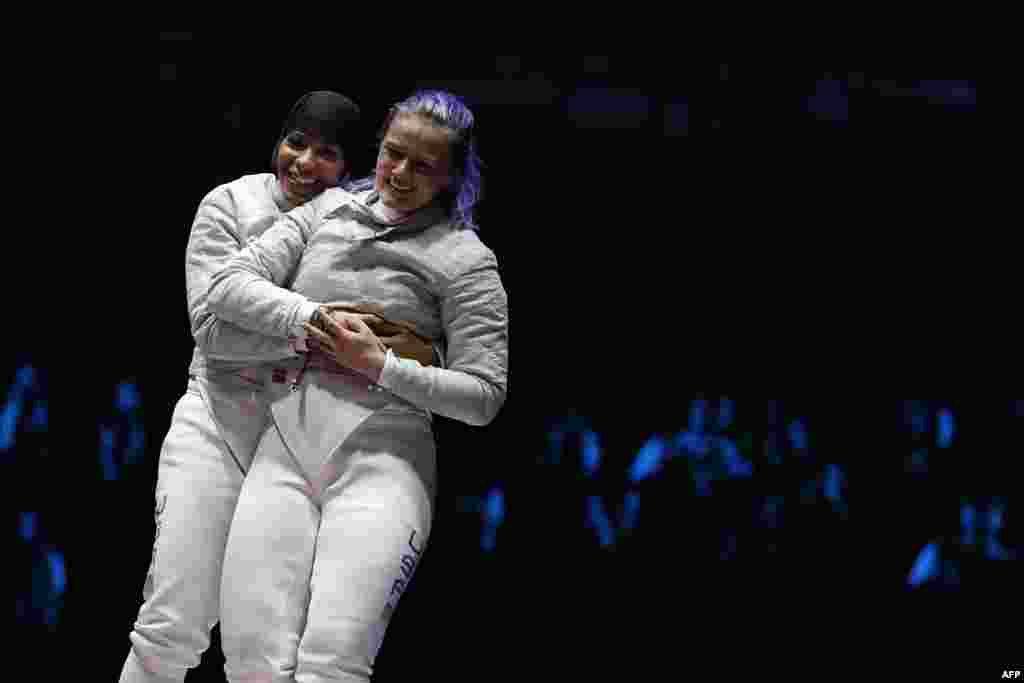 U.S. fencers Ibtihaj Muhammad (left) and Dagmara Wozniak celebrate after winning the women&rsquo;s team saber bronze medal bout with Italy.