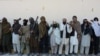 Alleged former Taliban fighters carry their weapons before handing them over as part of a government peace and reconciliation process at a ceremony in Jalalabad on February 24.