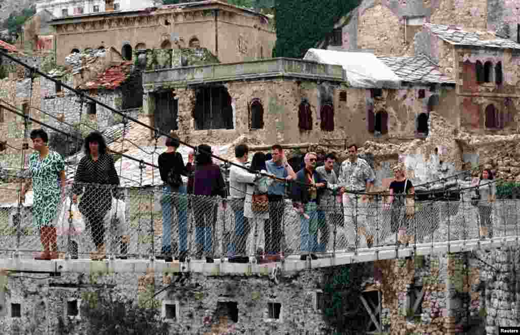 Građani prelaze preko improviziranog mosta, na mjestu srušenog Starog mosta u Mostaru, na dan izbora 14. 9. 1996.