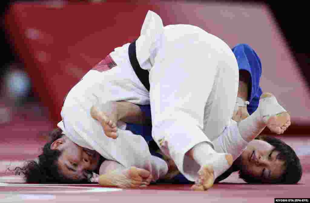 Чізуру Араі з Японії (у синьому) в бою проти Мадіни Таймазової з Росії (у білому) під час півфінального поєдинку таблиці B у дзюдо серед жінок у ваговій категорії до 70 кг на Олімпійських іграх 2020 року. Токіо, 28 липня 2021 року