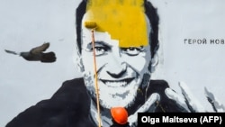 Egy szentpétervári közüzemi munkás festi át a Navalnijról készült falfestményt 2021 áprilisában