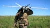 Військовий батальйону безпілотних літальних апаратів «Корсар» 38-ї окремої бригади морської піхоти несе розвідувальний БПЛА «Лелека» українського виробництва перед його запуском поблизу лінії фронту. Донеччина, 22 травня 2026 року 