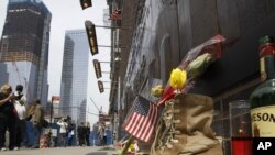 O sticlă whiskey, o candelă şi o pereche de bocanci militari, lângă zidul Memorialului 9-11, New York