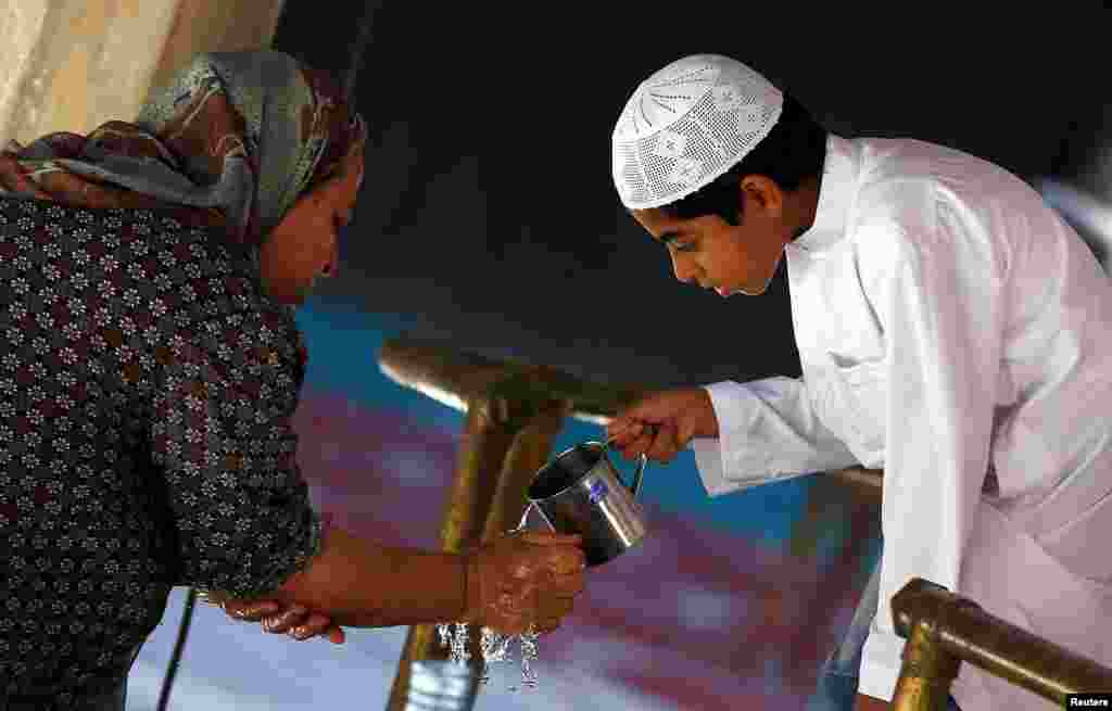 Misirli oğlan nənəsinə əlini yumağa yardım edir