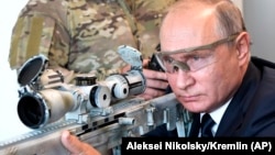 Russian President Vladimir Putin aims a sniper rifle during a visit to a military exhibition center outside Moscow on September 19.