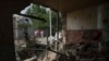 Люди дивляться на будинок, який був пошкоджений після обстрілу Росією житлового району в Нікополі, Україна, у понеділок, 22 серпня 2022 року. Фото ілюстративне