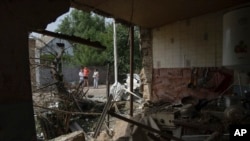 Люди дивляться на будинок, який був пошкоджений після обстрілу Росією житлового району в Нікополі, Україна, у понеділок, 22 серпня 2022 року. Фото ілюстративне