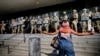 Un protestatar în fața unei linii a Gărzii Naționale din California care protejează o clădire federală în centrul orașului Los Angeles. Luni, 9 iunie 2025.