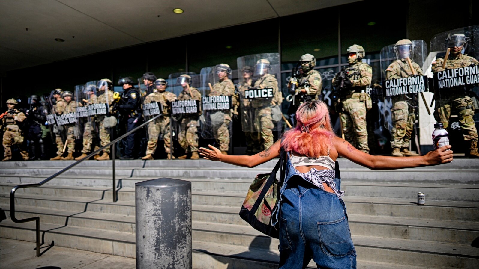 Un protestatar în fața unei linii a Gărzii Naționale din California care protejează o clădire federală în centrul orașului Los Angeles. Luni, 9 iunie 2025.
