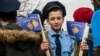 A young Kosovar boy dressed as a police officer holds Kosovar flags on the eve of the celebrations marking the 10th anniversary of Kosovo's independence, in Pristina on February 16.