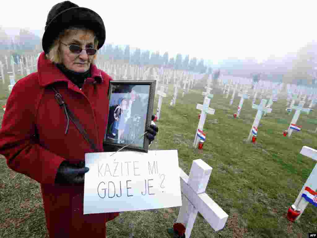 Jelena Radic, 63, shows a picture of her disappeared husband and war victim Mijo as she holds a sign reading, &quot;Tell me where is he?&quot; at a 1991 war victims cemetery in Vukovar, Croatia, on November 18. (AFP PHOTO/Hrvoje Polan)