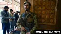 A member of the Afghan security forces stands guard at the Abdul Rahman Mosque in Kabul as people offer prayers for Eid al-Fitr on May 13.