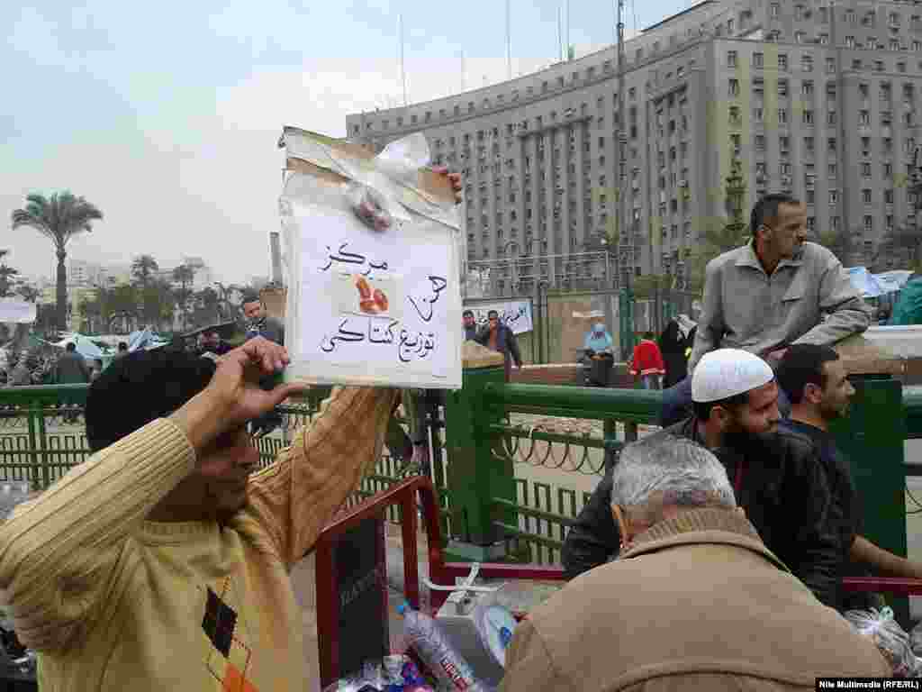 This man is holding a sign reading, "Here is the Kentucky distribution center," a reference to reports that pro-Mubarak supporters were being offered food from KFC to join counter-protests.