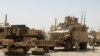 Iraq -- US soldiers stand next to army vehicles during a logistical operation to clear equipment and heavy machinery from the Balad military base, 27Aug2011