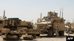 Iraq -- US soldiers stand next to army vehicles during a logistical operation to clear equipment and heavy machinery from the Balad military base, 27Aug2011