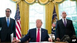 President Donald Trump listens to a reporter's question after signing an executive order to increase sanctions on Iran, in the Oval Office of the White House, Monday, June 24, 2019, in Washington. Trump is accompanied by Treasury Secretary Steve Mnuchin, left, and Vice President 