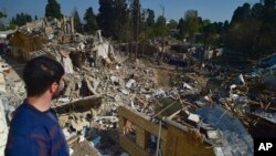 კაცი უყურებს დაბომბვის შედეგად განადგურებულ საცხოვრებელ სახლს. განჯა, აზერბაიჯანი. 13 ოქტომბერი, 2020