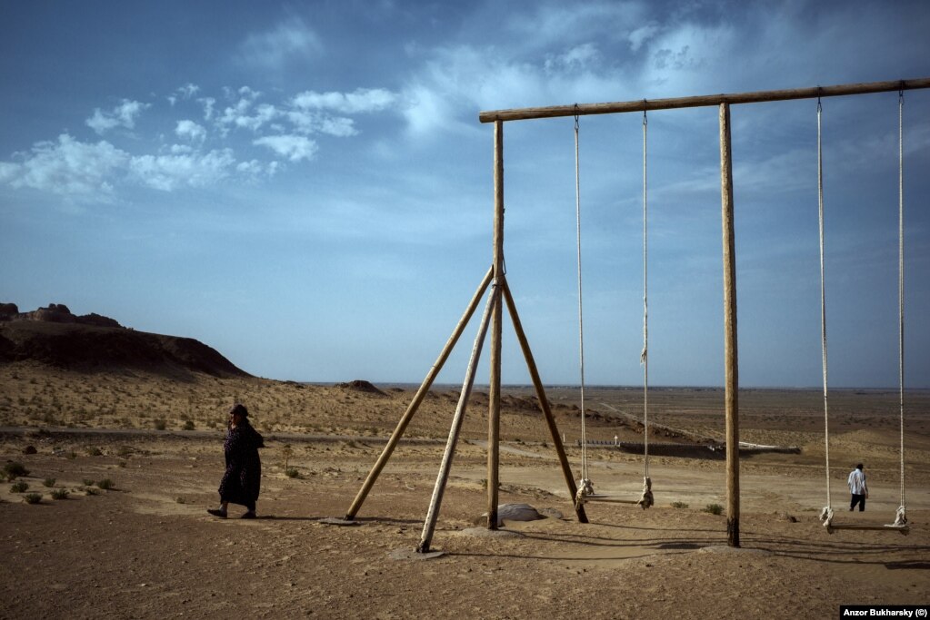 A set of swings in the dusty expanse of the desert of Karakalpakstan in the north of Uzbekistan.