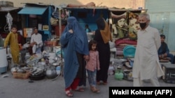 Avganistanka pod burkom kod prodavnice s polovnim kućevnim predmetima, 25. avgust 2021.