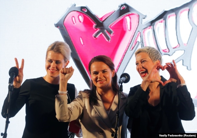 Светлана Тихановская (в центре), Вероника Цепкало (слева) и Мария Колесникова во время предвыборного митинга в Минске 30 июля 2020. Победа, кулак и сердце – три символа кампании Тихановской