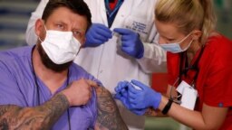 Сотрудник одной из варшавских больниц получает прививку от коронавируса